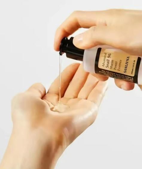 Hydrating facial essence for sensitive skin being dispensed from a black pump bottle onto hand