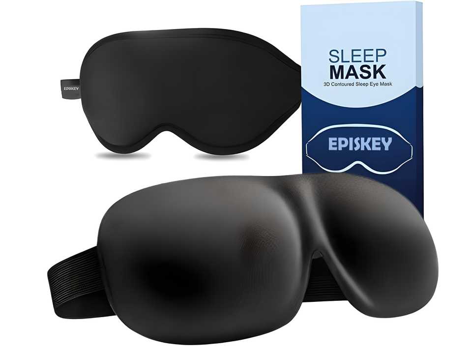 Black light blocking eye mask with contoured design and adjustable strap next to blue and white sleep mask box