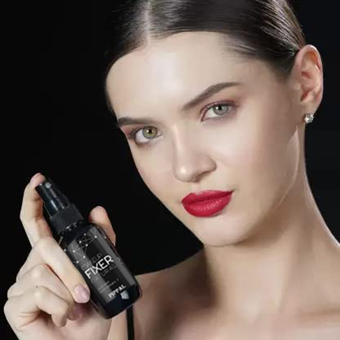 Woman holding long-lasting hydrating makeup spray in black bottle with pump applicator
