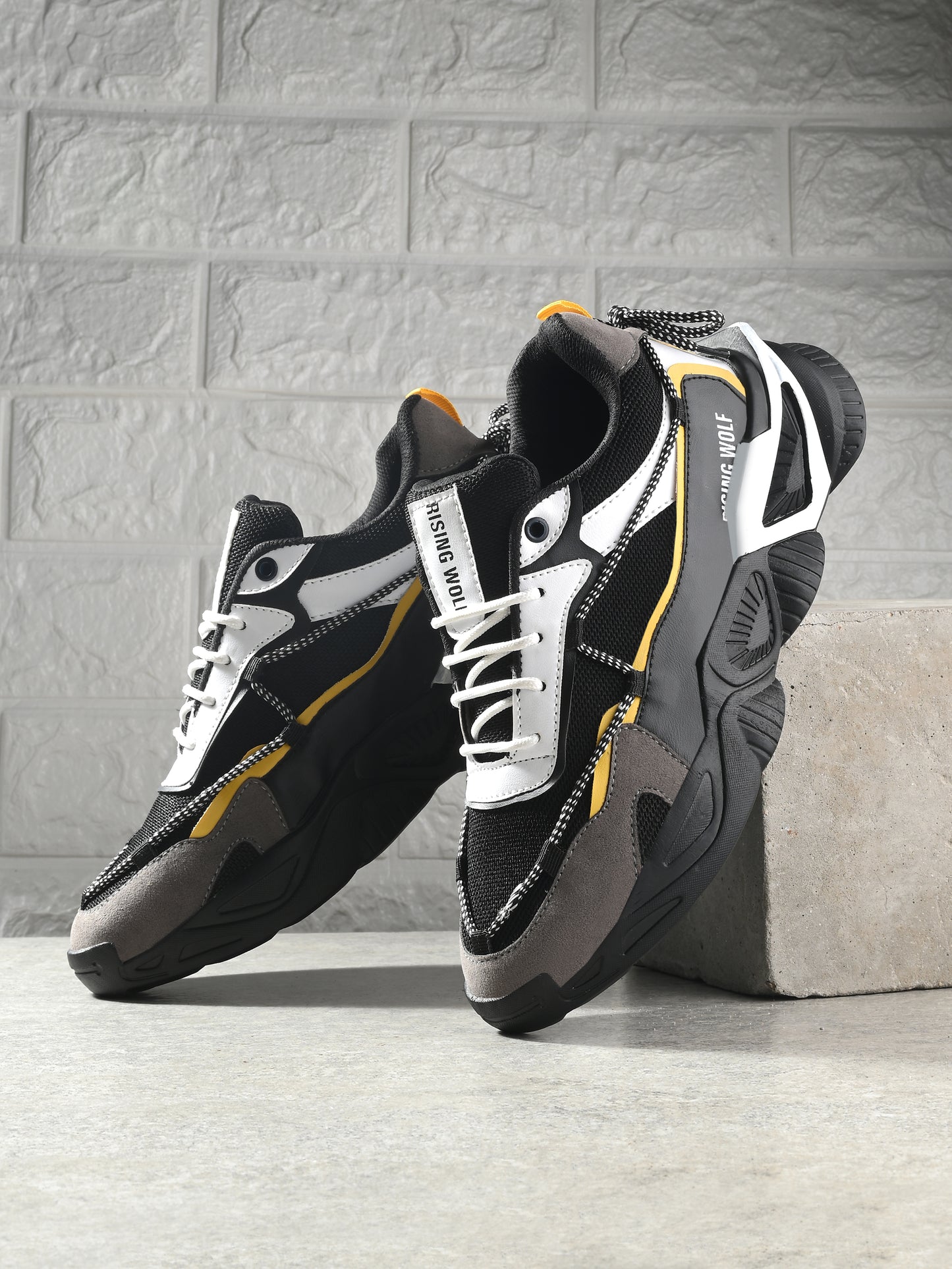 Black and white leather running shoes for everyday wear with yellow accents and thick soles