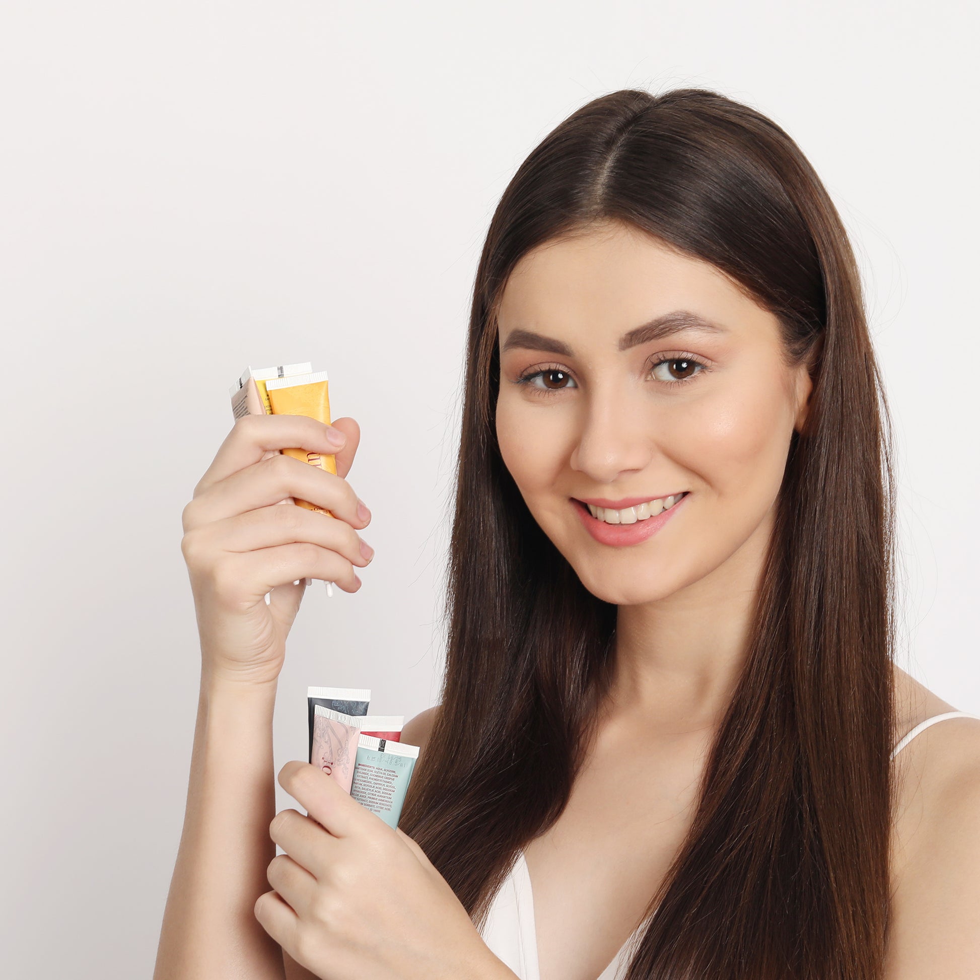 Smiling woman holding facial kits featuring the best moisturizer for glowing skin skincare products