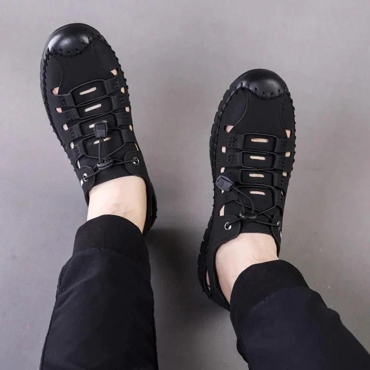 Black mens casual slip on shoes with breathable design and secure lace closure worn with black pants
