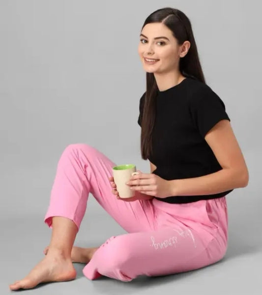 Woman wearing comfortable cotton blend pants for ladies in pink sitting with a cup and smiling