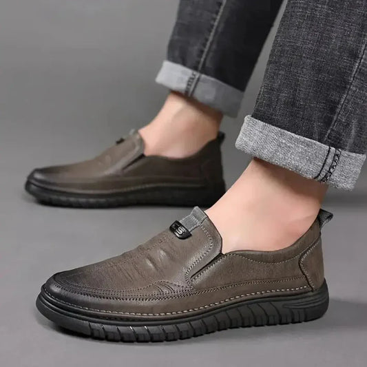 Men's formal comfortable everyday leather shoes in brown with black sole, worn with rolled-up jeans