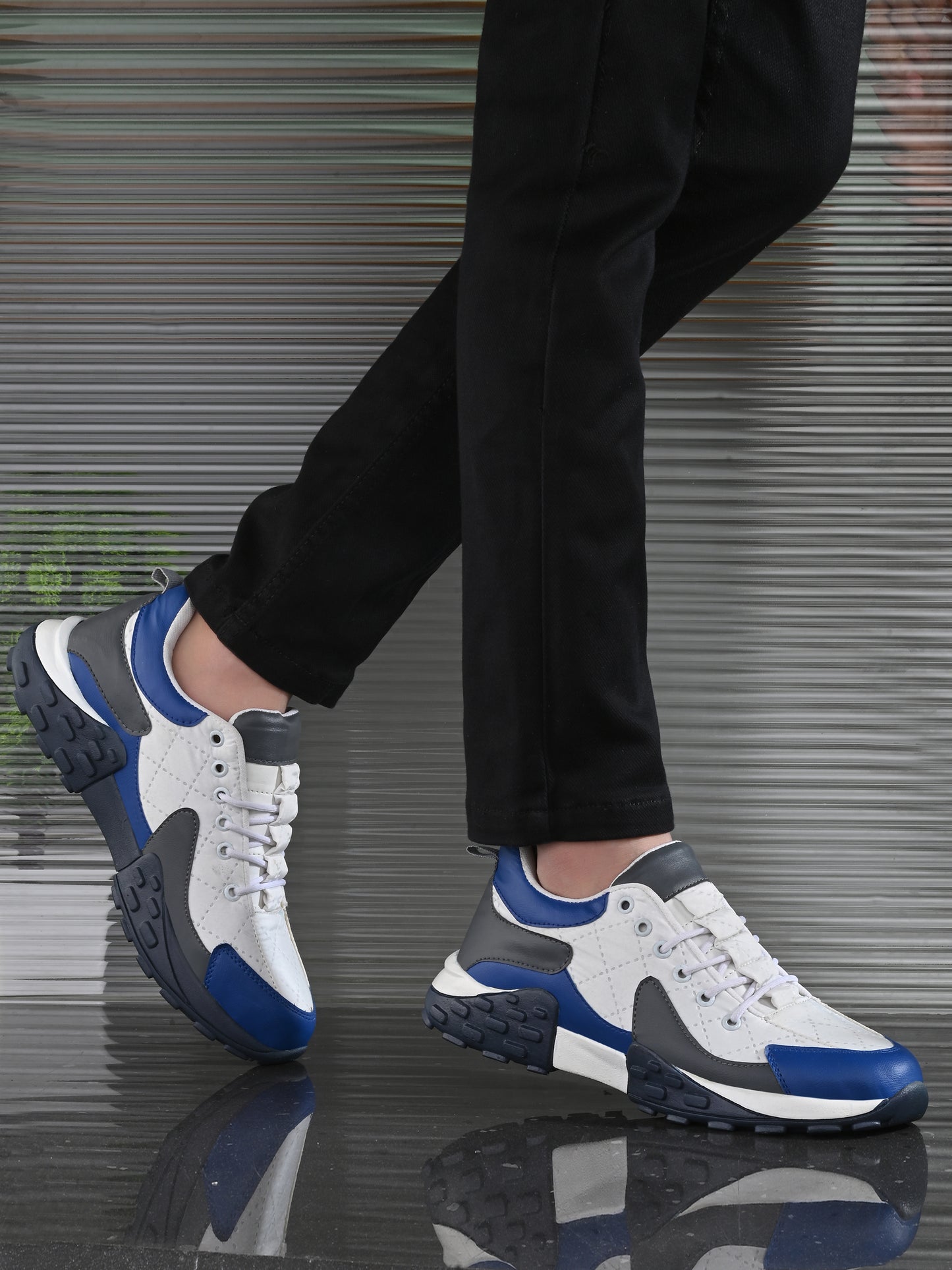 Men's casual comfortable white running shoes with blue and gray accents worn with black pants