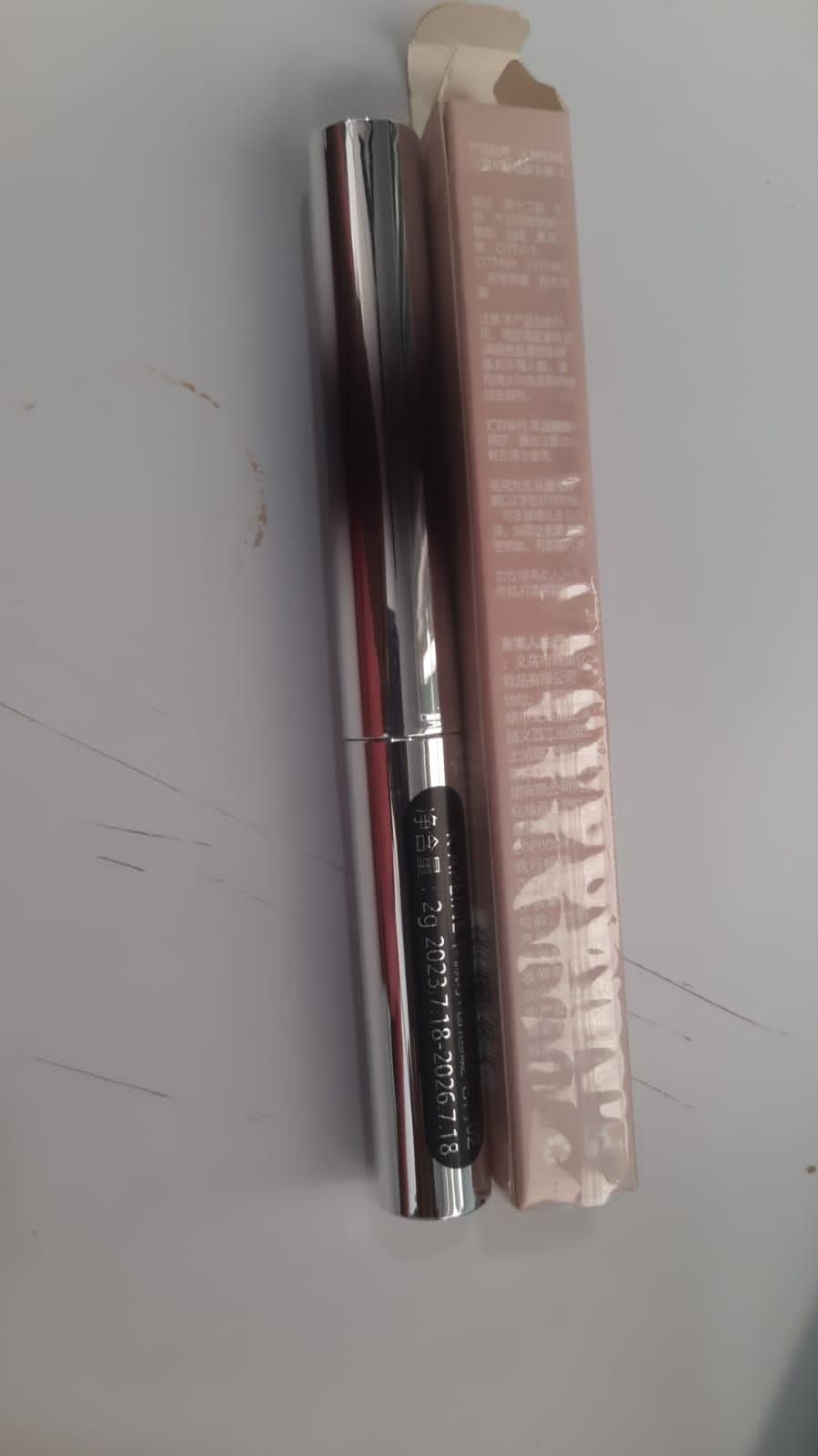 19378 eye serum packaging next to mascara for curled lashes in reflective silver tube