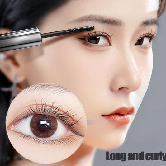 Woman applying mascara for curled lashes on long, defined eyelashes with close-up detail view